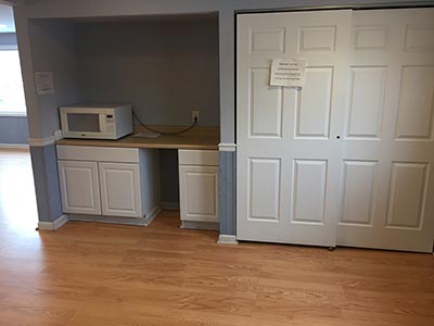 area with closed closet doors and microwave